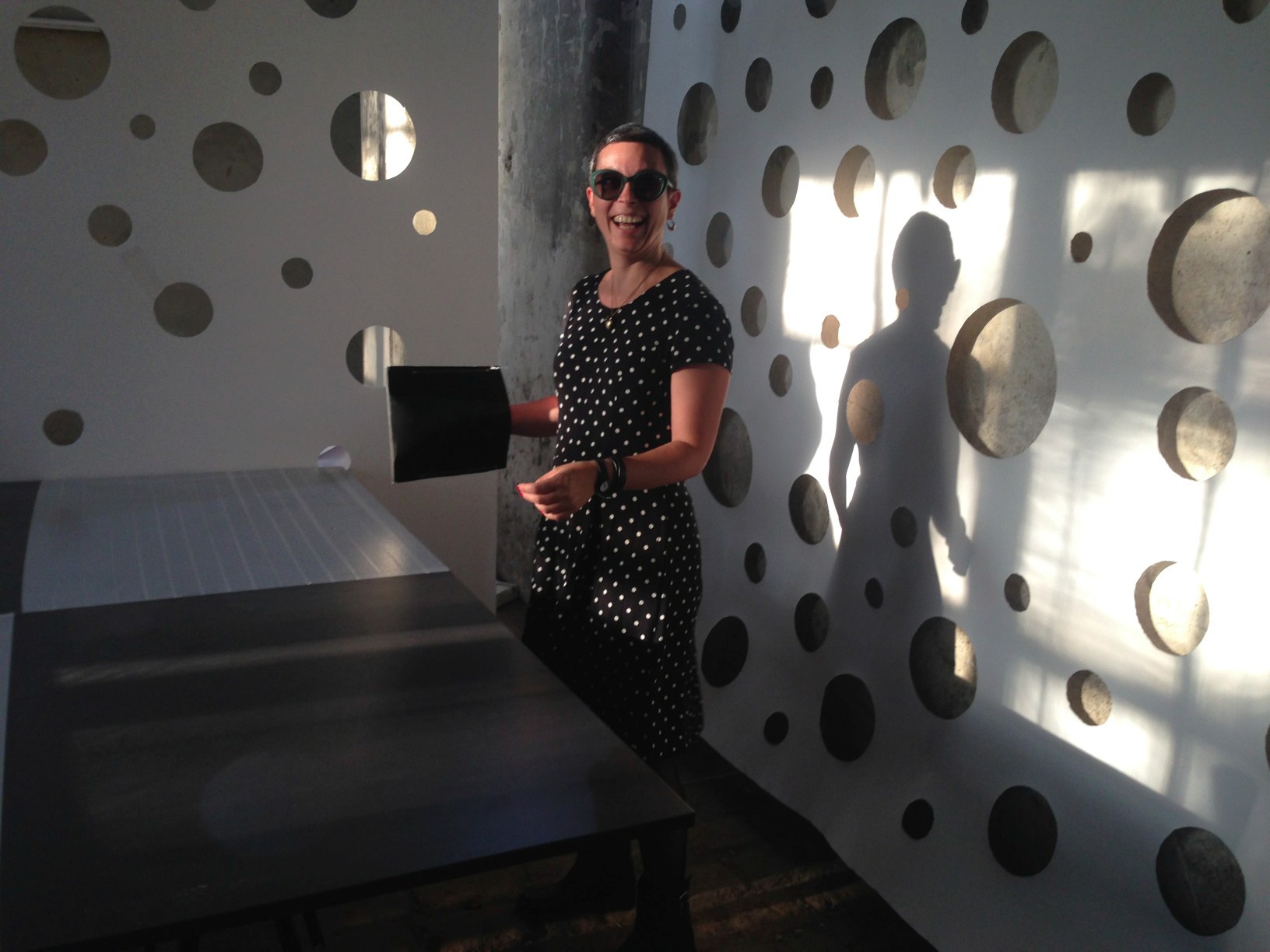 Image from Vienna Design Week - Labor workshop: A women lough in dotted suit in fornt of the dotted wall